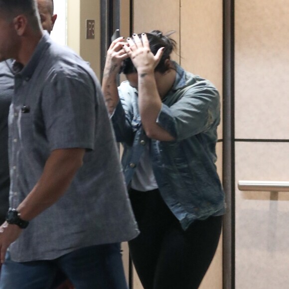 Exclusif - Demi Lovato fait des doigts d'honneur aux photographes à la sortie de son cours de gym accompagnée de son garde du corps à Beverly Hills. Le 20 novembre 2018.