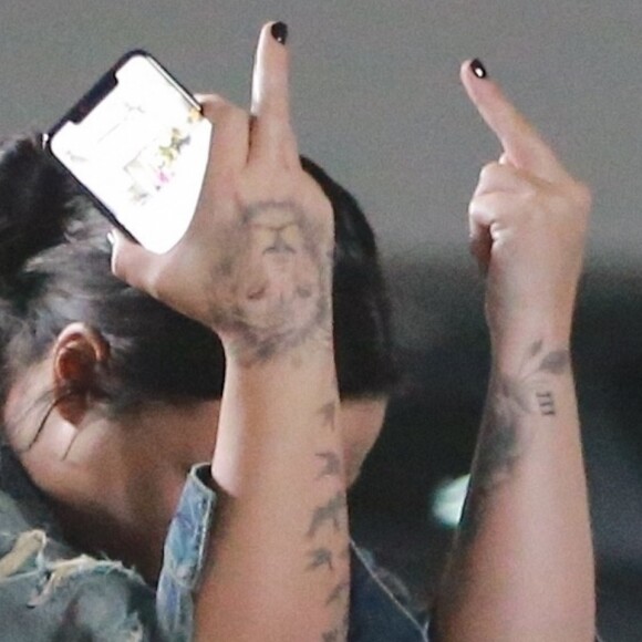 Exclusif - Demi Lovato fait des doigts d'honneur aux photographes à la sortie de son cours de gym accompagnée de son garde du corps à Beverly Hills. Le 20 novembre 2018.
