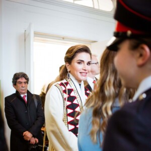 La reine Rania de Jordanie, habillée d'un manteau Obadia et accessoirisée d'un sac Okhtein, lors de la cérémonie de fin de formation de la princesse Salma à l'Académie militaire royale de Sandhurst en Angleterre le 24 novembre 2018.