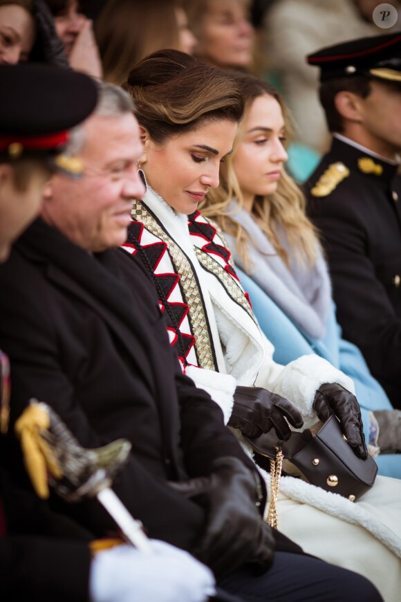 La reine Rania de Jordanie, habillée d'un manteau Obadia et accessoirisée d'un sac Okhtein, lors de la cérémonie de fin de formation de la princesse Salma à l'Académie militaire royale de Sandhurst en Angleterre le 24 novembre 2018.