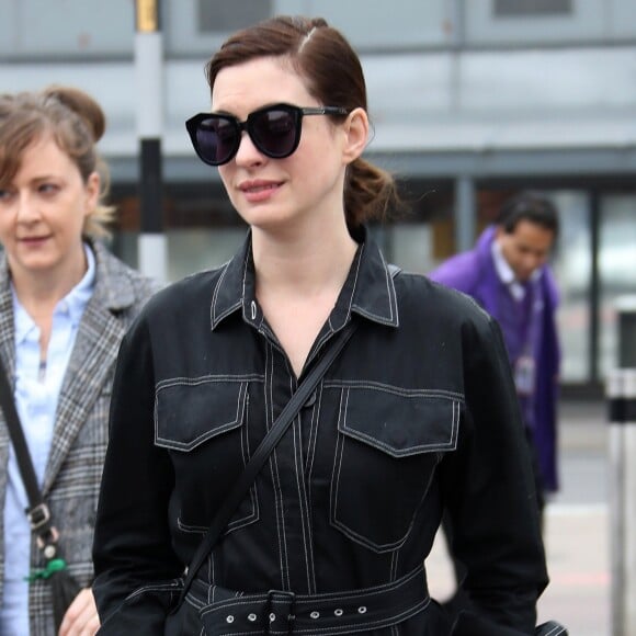 Anne Hathaway arrive à l'aéroport Heathrow, elle porte une combinaison noire et des mules plates en cuir noire, Londres, le 8 avril 2019.