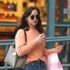 Dakota Johnson fait du shopping sur Melrose à Los Angeles. L'actrice porte un jean taille haute, un pull couleur pêche, des mocassins rose pâle et un sac à main Gucci, le 12 novembre 2017.