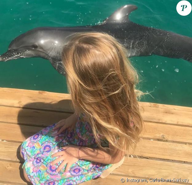 Carla Bruni-Sarkozy poste cette incroyable photo de Giulia avec un dauphin pendant leur vacances, sur Instagram le 16 juillet 2019.