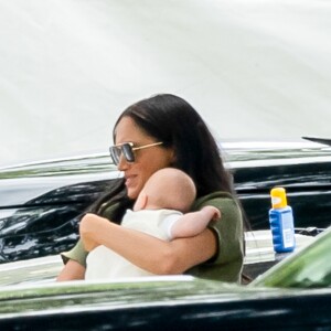 Meghan Markle, duchesse de Sussex, avec son fils Archie dans les bras le 10 juillet 2019 dans le Berkshire lors d'un tournoi de polo disputé par le prince Harry à Wokinghan.