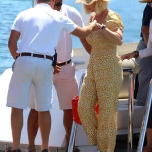 Katy Perry porte une combinaison pantalon fleurie et un chapeau de paille à son arrivée en bateau à Ibiza, le 28 juillet 2019.