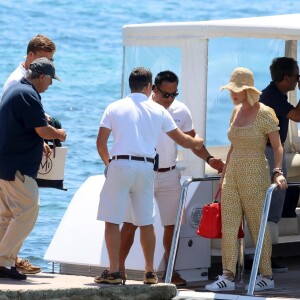 Katy Perry porte une combinaison pantalon fleurie et un chapeau de paille à son arrivée en bateau à Ibiza, le 28 juillet 2019.