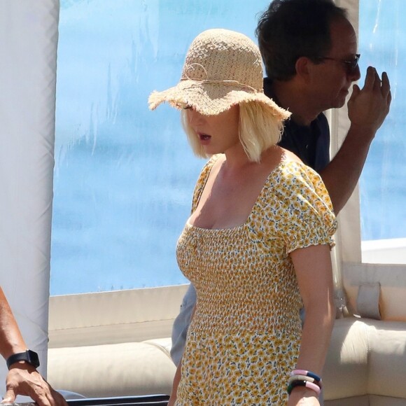 Katy Perry porte une combinaison pantalon fleurie et un chapeau de paille à son arrivée en bateau à Ibiza, le 28 juillet 2019.