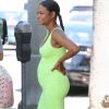Christina Milian enceinte porte une robe vert fluo très moulante devant son Beignet Box truck à Studio City, Los Angeles, le 29 août 2019