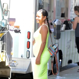 Christina Milian enceinte porte une robe vert fluo très moulante devant son Beignet Box truck à Studio City, Los Angeles, le 29 août 2019