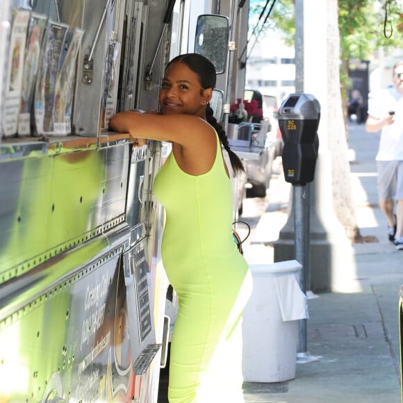 Christina Milian enceinte porte une robe vert fluo très moulante devant son Beignet Box truck à Studio City, Los Angeles, le 29 août 2019