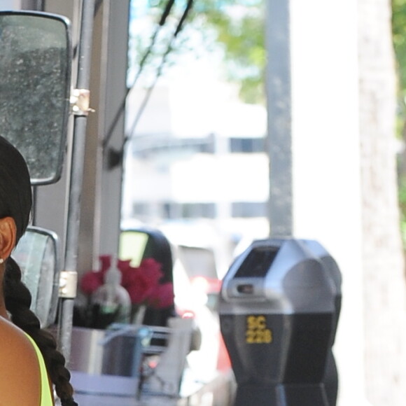 Christina Milian enceinte porte une robe vert fluo très moulante devant son Beignet Box truck à Studio City, Los Angeles, le 29 août 2019
