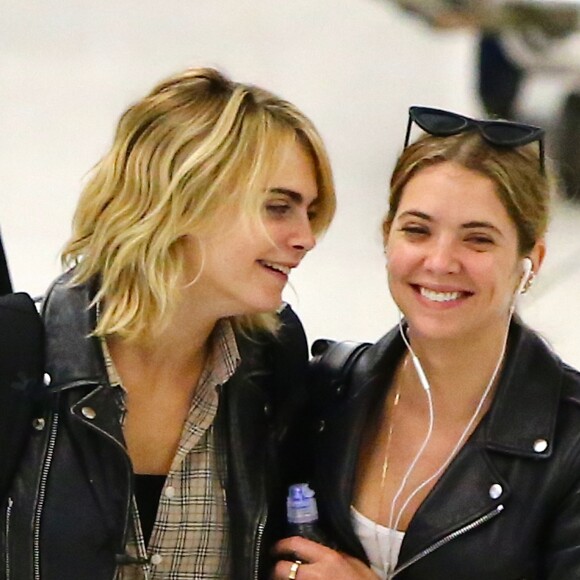 Cara Delevingne et sa petite amie Ashley Benson arrivent à l'aéroport JFK de New York le 18 juin 2019. Le couple échange des baisers derrière la file de sécurité.