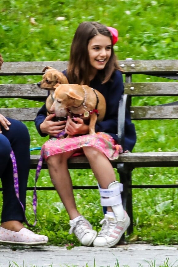 Suri Cruise, une attelle a la cheville, joue avec ses chiens dans un parc a New York, le 23 juin 2018.