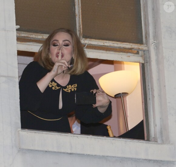 La chanteuse Adèle à la fenêtre du Wiltern Theatre à Los Angeles après son concert en présence de nombreuses célébrités le 13 février 2016