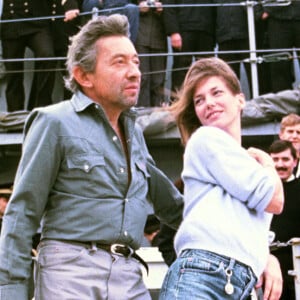 Archives - Serge Gainsbourg et Jane Birkin sur le pont d'un bateau de la marine française pour une émission "Formule 1". Le 16 novembre 1984.