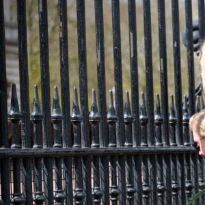 Les Britanniques déposent des fleurs devant les grilles de Buckingham Palace après l'annonce du décès du prince Philip à Londres, le 9 avril 2021.