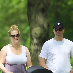 Amy Schumer et son mari Chris Fischer promènent leur fils Gene Attell Fischer en poussette dans un parc à New York, le 18 mai 2019.