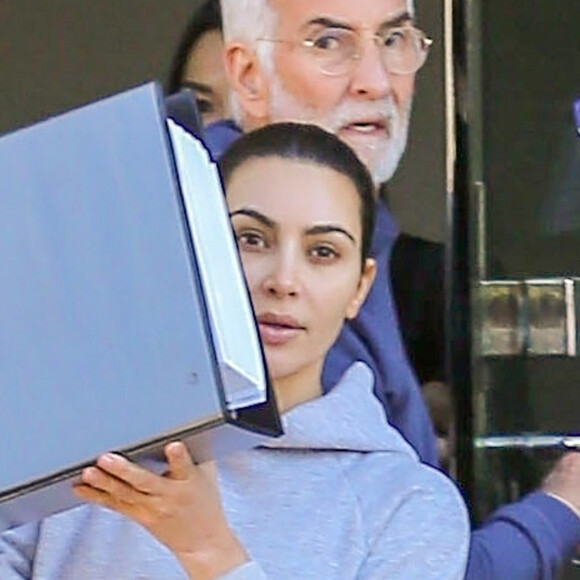 Kim Kardashian (sans maquillage) essaie de se cacher des photographes avec un classeur à la sortie des bureaux de son mari K. West à Los Angeles, le 6 janvier 2020.