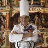 En France, Paul Bocuse posant au château d'Ecully, dans lequel est installée l'école des Arts Culinaires et de l'hôtellerie. Il pose devant un limonaire ( ou orgue de barbarie ) Gaudin datant de 1895, provenant de sa collection le 17 novembre 1993.17/11/1993 -