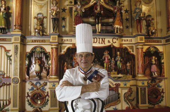 En France, Paul Bocuse posant au château d'Ecully, dans lequel est installée l'école des Arts Culinaires et de l'hôtellerie. Il pose devant un limonaire ( ou orgue de barbarie ) Gaudin datant de 1895, provenant de sa collection le 17 novembre 1993.17/11/1993 -