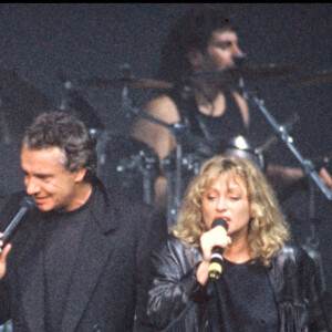 Johnny Hallyday, Michel Sardou, Véronique Sanson et Eddy Michell sur scène pour un concert lors de la tournée des Enfoirés en 1989.
