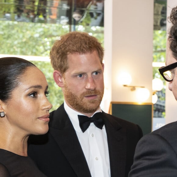 Le prince Harry, duc de Sussex, et Meghan Markle, duchesse de Sussex, avec John Favreau à la première du film "Le Roi Lion" au cinéma Odeon Luxe Leicester Square à Londres, le 14 juillet 2019.