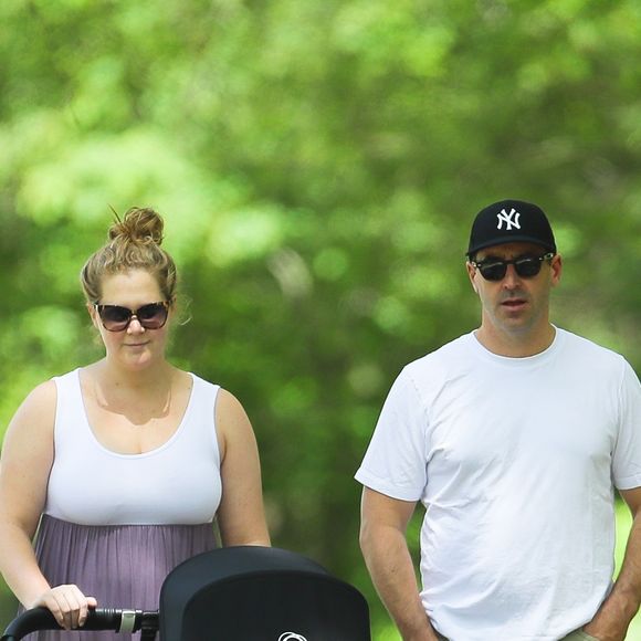 Amy Schumer et son mari Chris Fischer promènent leur fils Gene Attell Fischer en poussette dans un parc à New York, le 18 mai 2019