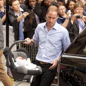 Le prince William et Kate Middleton, duchesse de Cambridge quittent l'hopital St-Mary avec leur fils George de Cambridge a Londres le 23 juillet 2013.