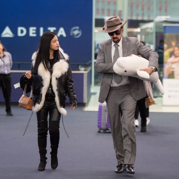 Exclusif - Nicolas Cage et sa nouvelle compagne Riko Shibatase arrivent de l'aquarium d'Atlanta à l'aéroport JFK à New York, le 28 février 2020. Nicolas a rapporté un petit souvenir de leur voyage, un beluga en peluche.