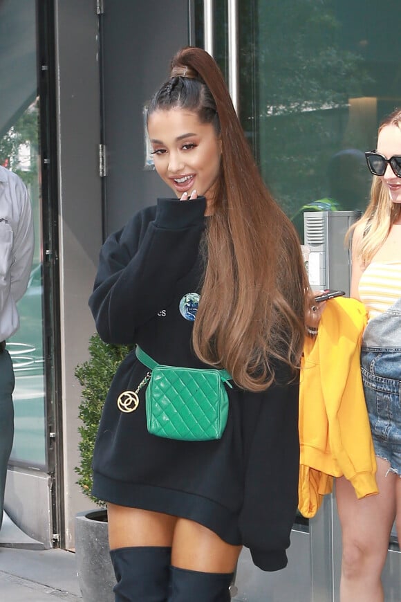 Ariana Grande quitte son appartement à New York. La chanteuse a été aperçue ave une amie et sans son fiancé P. Davidson. Ariana se dirige vers les studios de la NBC. Elle porte un sweat oversize, des cuissardes noires et une banane Chanel verte, le 16 aout 2018.