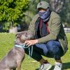 Exclusif - Henry Golding, équipé d'un foulard en guise de masque, promène son pitbull Stella dans un parc, en marge du confinement à Santa Monica, le 23 avril 2020.