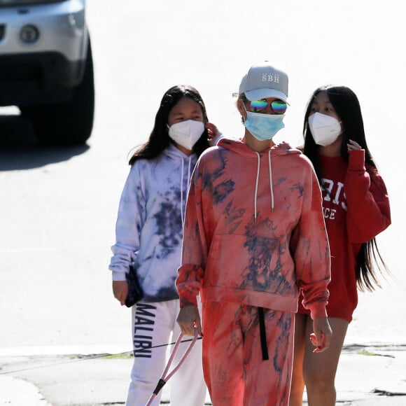 Laeticia Hallyday, ses filles Jade et Joy, Christina, avec des masques, et leurs chiens Santos, Cheyenne et Bono se promènent dans le quartier de Pacific Palisades, à Los Angeles, Californie, Etats-Unis, le 3 avril 2020, pendant la période de confinement.