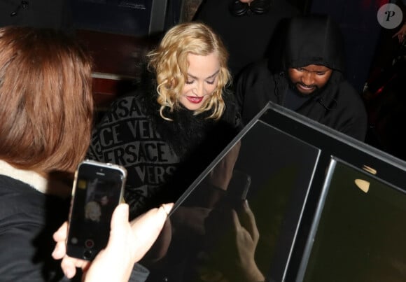 Exclusif - Madonna porte un ensemble Versace à la sortie du London Palladium accompagnée d'un mystérieux inconnu à Londres, le 8 février 2020.