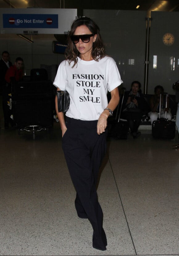 Victoria Beckham porte un t-shirt de sa collection Victoria by Victoria Beckham avec le slogan 'Fashion Stole My Smile' à son arrivée à l'aéroport de LAX à Los Angeles, le 28 mars 2017
