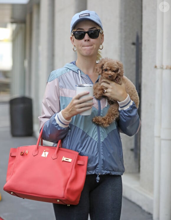 Exclusif - Katy Perry se promène avec son petit chien Nugget dans les rues de Santa Monica, Los Angeles, le 9 août 2019. Elle porte un legging, un k-way, une casquette avec l'inscription "Nugget" (le prénom de son chien), des lunettes de soleil et un sac Hermès rouge. Katy est de retour à Los Angeles après avoir passé des vacances en Italie avec son fiancé O. Bloom.