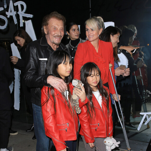 Johnny Hallyday, sa femme Laeticia (en béquilles) et leurs filles Jade et Joy au vernissage de l'exposition du photographe Mathieu Cesar à Los Angeles. Le 21 février 2017