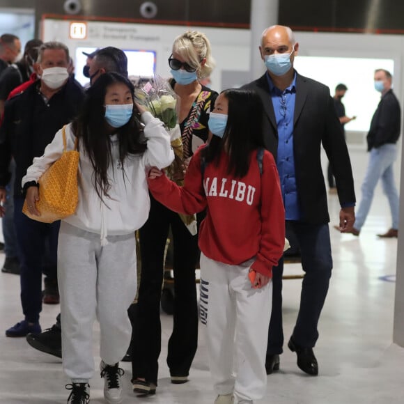 Laeticia Hallyday et ses filles Jade et Joy arrivent, avec des masques de protection contre l'épidémie de coronavirus (Covid-19), à l'aéroport de Paris-Charles-de-Gaulle à Roissy-en-France, France, le 18 juin 2020.