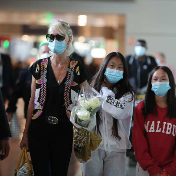 Laeticia Hallyday et ses filles Jade et Joy arrivent, avec des masques de protection contre l'épidémie de coronavirus (Covid-19), à l'aéroport de Paris-Charles-de-Gaulle à Roissy-en-France, France, le 18 juin 2020.
