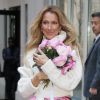 Celine Dion rayonnante et très souriante dans un ensemble pull écru et jupe bouffante fleurie salue ses fans à la sortie de son hôtel à New York, le 8 mars 2020