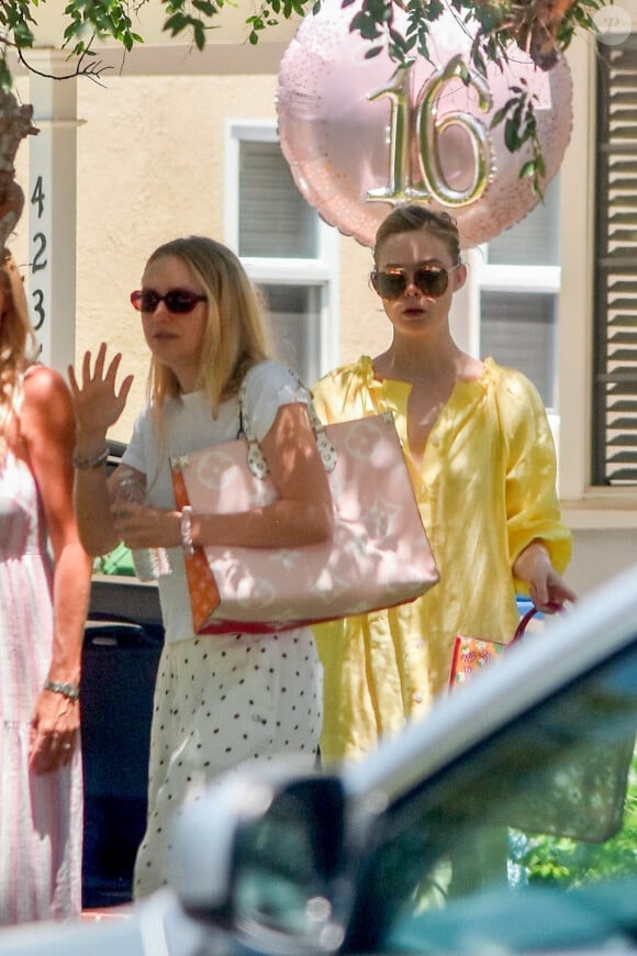 Exclusif - Dakota (en blanc) et sa soeur Elle Fanning (robe jaune) quittent la fête du 16e anniversaire d'une amie à Los Angeles, le 15 juin 2020.