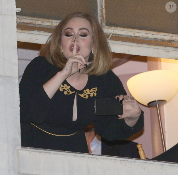 La chanteuse Adèle à la fenêtre du Wiltern Theatre à Los Angeles après son concert en présence de nombreuses célébrités le 13 février 2016.