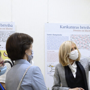 Brigitte Macron et la femme du président de Lettonie Andra Levite visitent l'exposition des dessins de presse "Dessins en liberté" à la Maison de l'Europe à Riga, le 30 septembre 2020