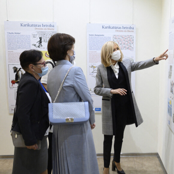 Brigitte Macron et la femme du président de Lettonie Andra Levite visitent l'exposition des dessins de presse "Dessins en liberté" à la Maison de l'Europe à Riga, le 30 septembre 2020