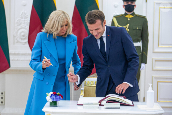 Brigitte Macron et Emmanuel Macron signent le livre d'or au palais présidentiel lituanien lors de son voyage officiel à Vilnius le 28 septembre 2020