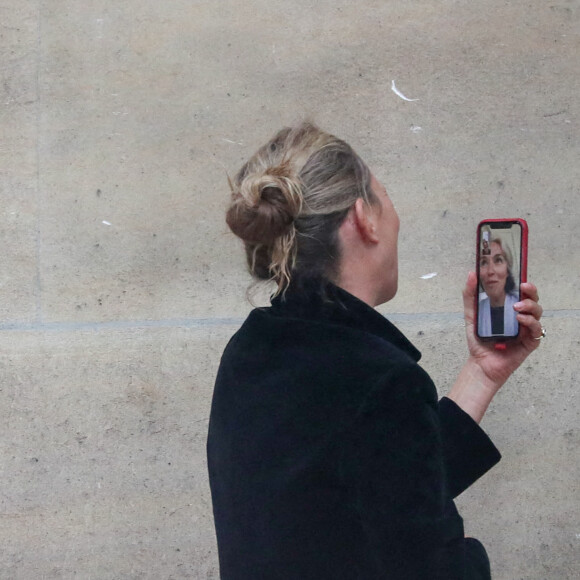 Kate Moss en FaceTime avec un proche lors du défilé haute couture printemps/été 2021 Fendi à Paris le 27 janvier 2021.