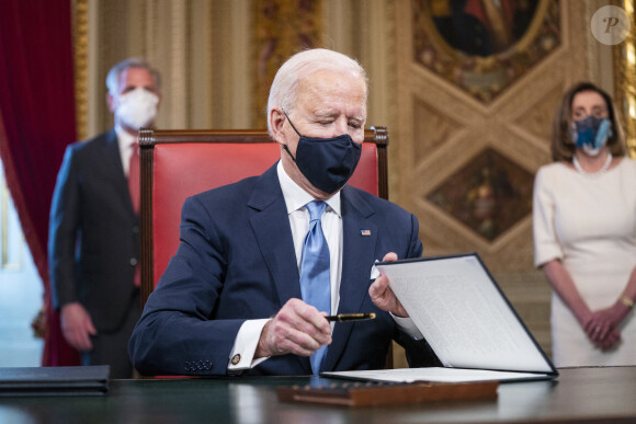 Le 46ème président des Etats-Unis Joe Biden lors de la signature de ses premiers décrets, juste après son investiture, dans le bureau ovale de la Maison Blanche à Washington.