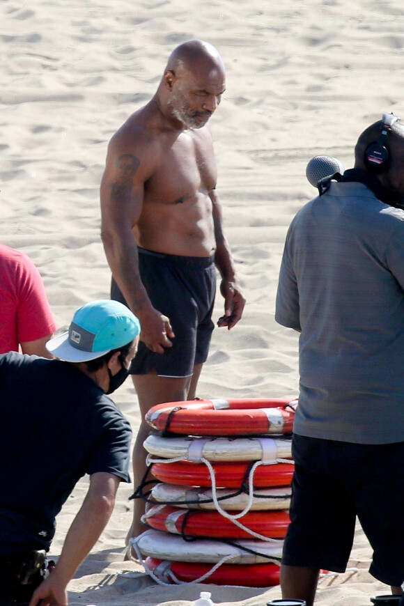Exclusif - Le grand boxeur Mike Tyson en tournage sur une plage à Los Angeles, le 1er juillet 2020. Il a participé à de nombreuses activités de plage comme renverser une cage à requins, soulever de grandes quantités de poissons morts et sauver des vies. Il porte un équipement de plongée et des flotteurs aux bras.