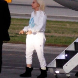 Lady Gaga retourne en avion à Los Angeles après sa prestation à l'investiture de Joe Biden, sans oublier sa robe Schiaparelli le 20 janvier 2021. Son compagnon, Michael Polansky a choisi de voyager à l'aise, en short et tongs