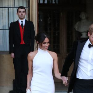 Le prince Harry, duc de Sussex, et Meghan Markle, duchesse de Sussex quittent le château de Windsor à bord d'une Jaguar Type E cabriolet en tenue de soirée après leur cérémonie de mariage, pour se rendre à la réception à "Frogmore House" à Windsor le 19 mai 2018.