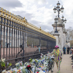 Les Anglais viennent rendrent hommage au prince Philip, duc d'Edimbourg devant les grilles de Buckingham Palace à Londres le 11 avril 2021.